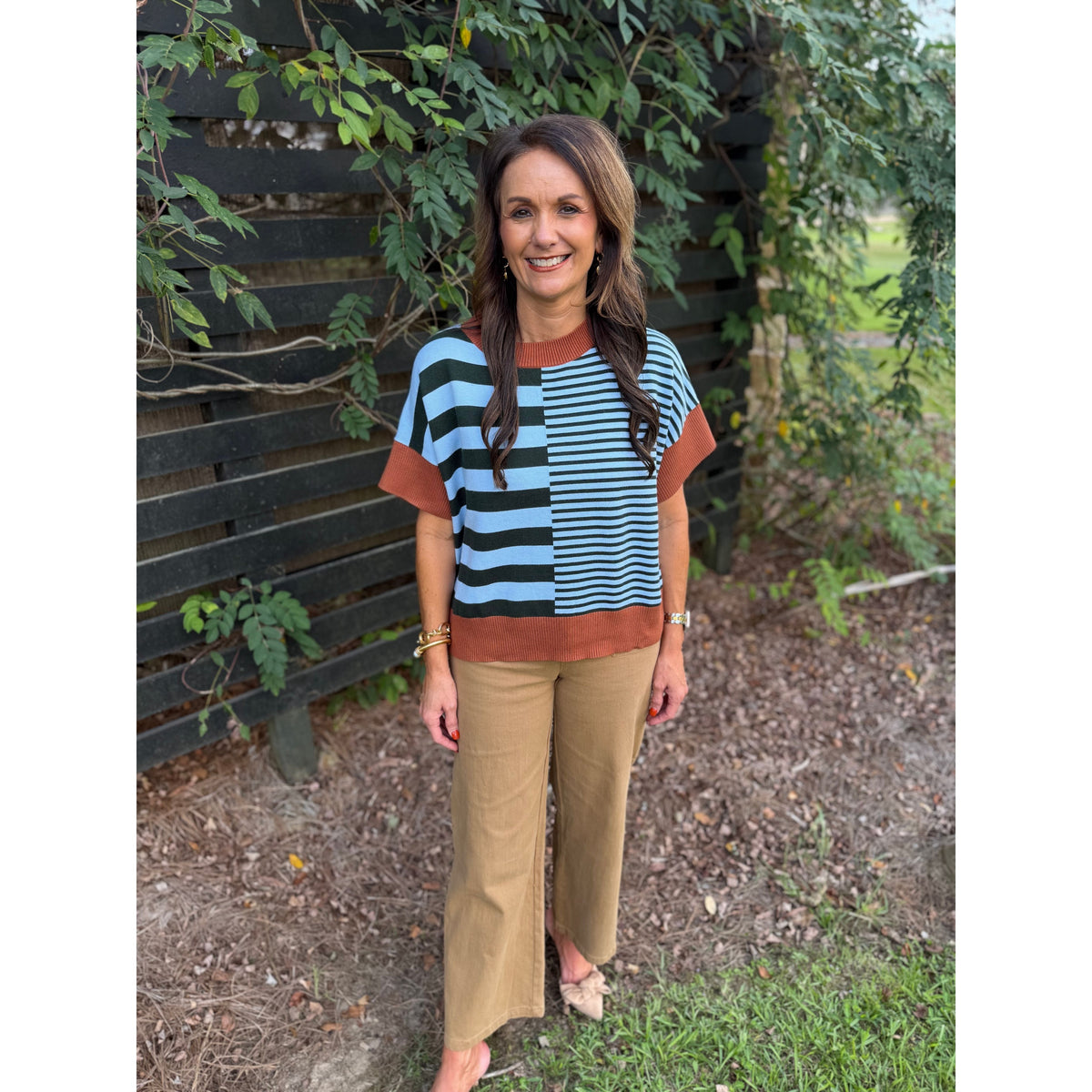 Annie Ks Boutique caramel and sea green striped drop-shoulder sweater worn by a woman with brown hair outdoors.