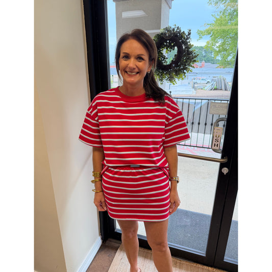 Annie Ks Boutique model wearing a red and powder blue striped boxy top and matching mini skort set in a bright shop.