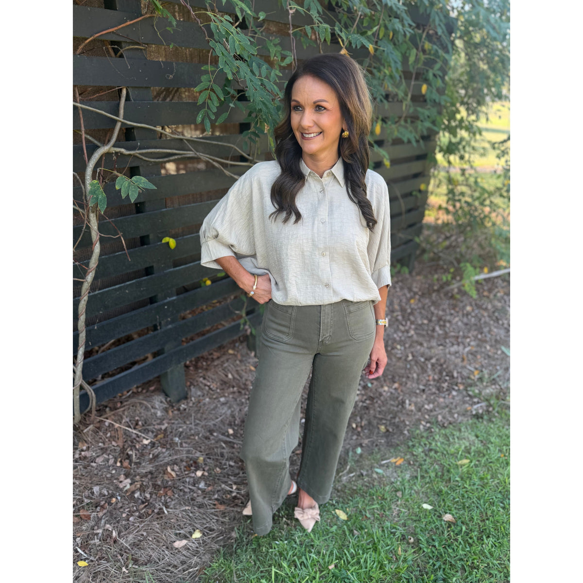 Annie Ks Boutique tan textured short sleeve blouse with dolman sleeves and button-front worn with olive trousers