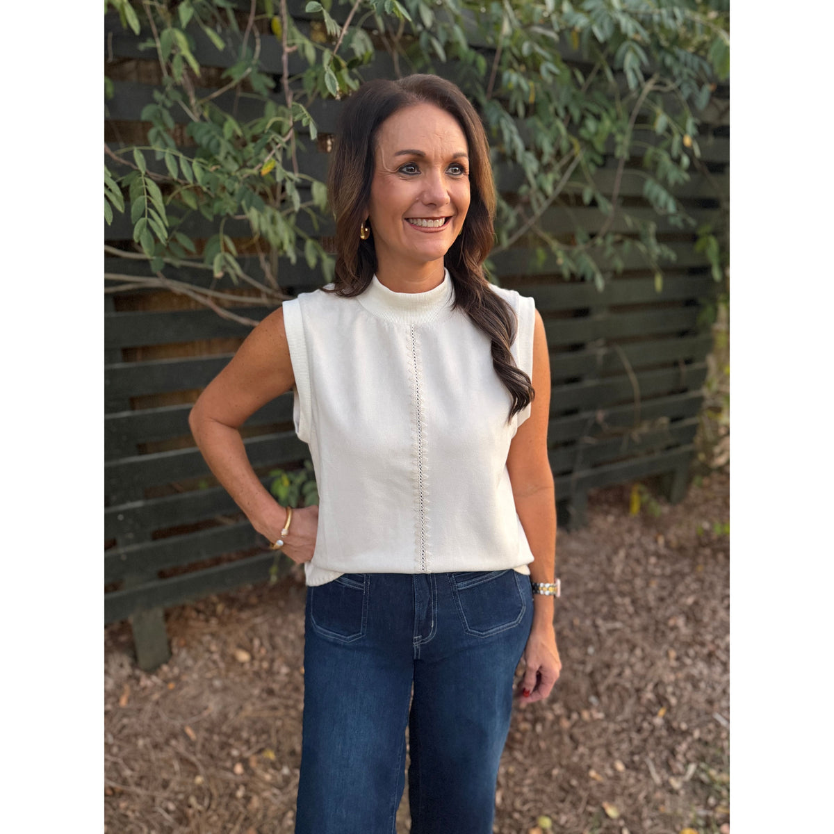 Woman wearing an Annie Ks Boutique THML cream sleeveless top with delicate stitching details and a crew neckline