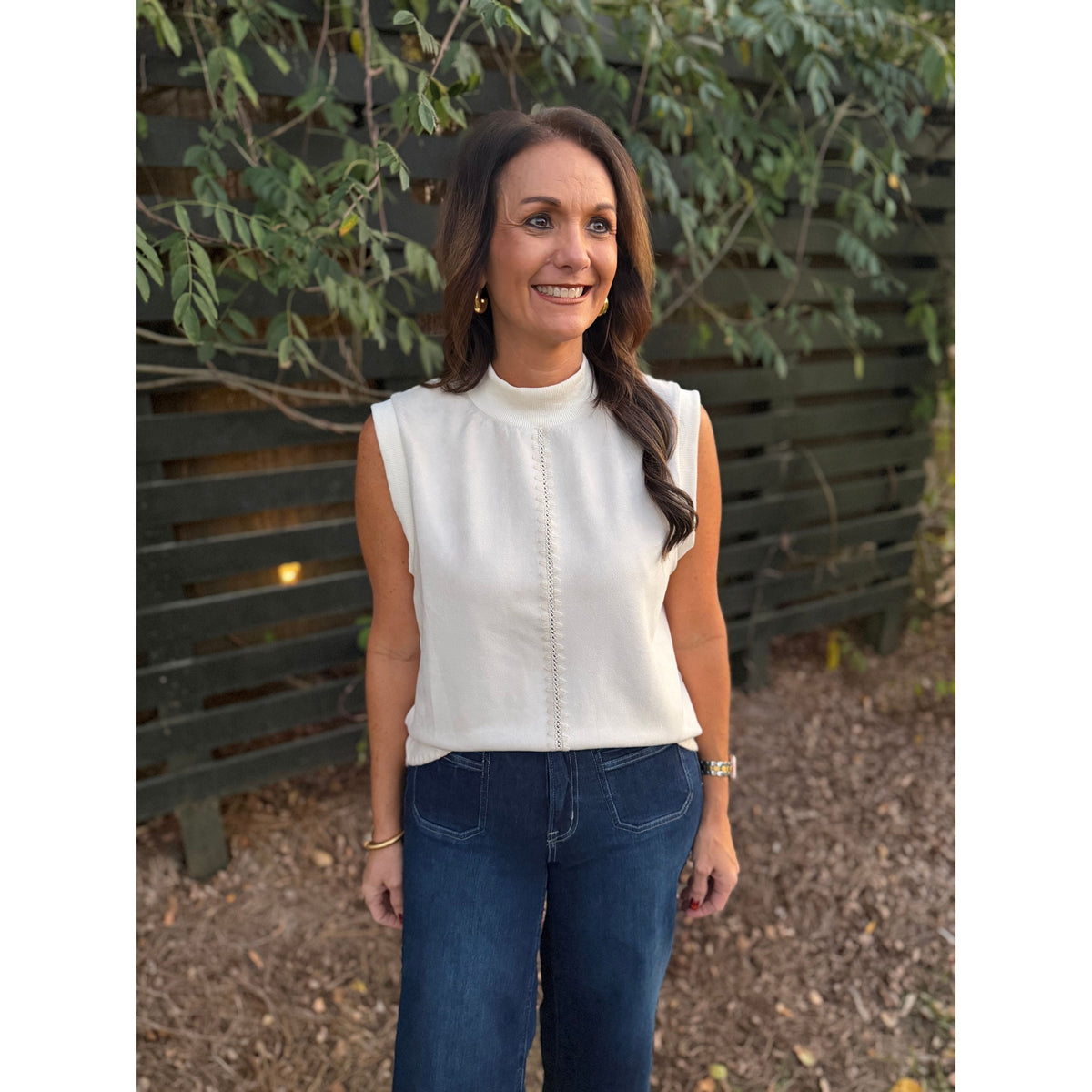 Annie Ks Boutique THML cream sleeveless knit top with mock neck and vertical stitching detail worn by a woman