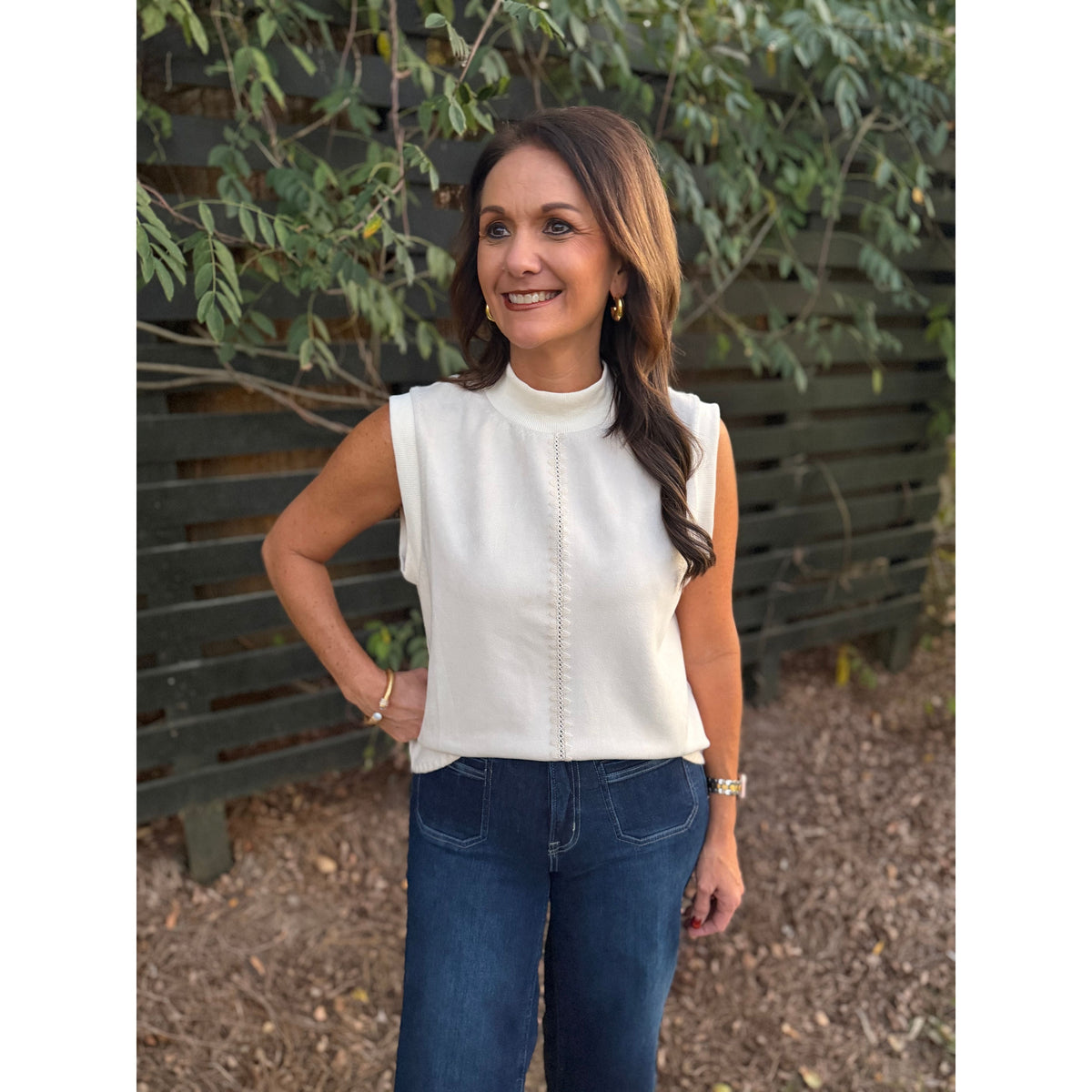 Annie Ks Boutique THML cream sleeveless top with mock neck and vertical stitch detail worn by a smiling woman