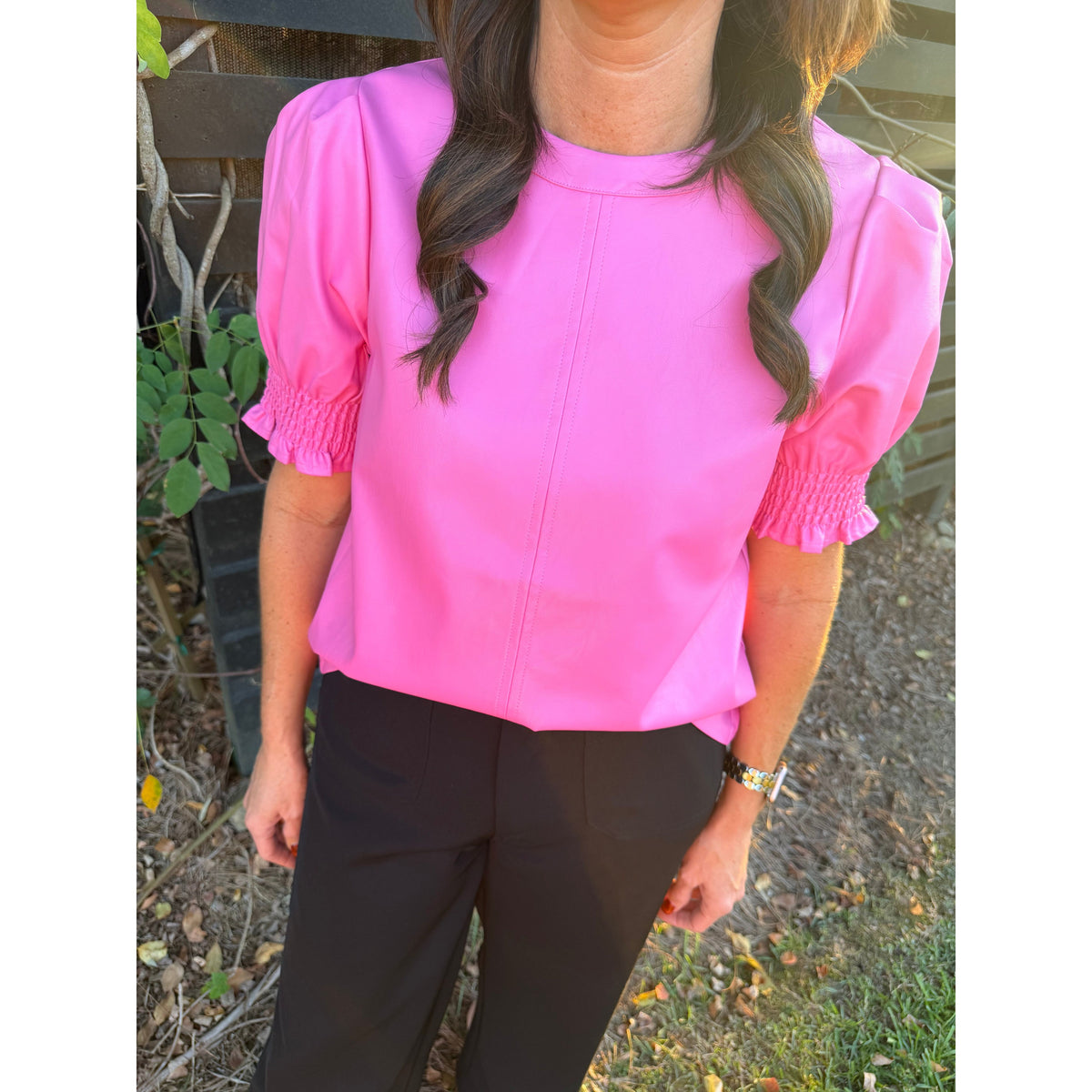 Annie Ks Boutique THML pink faux leather top with short puff sleeves and smocked cuffs worn with black trousers
