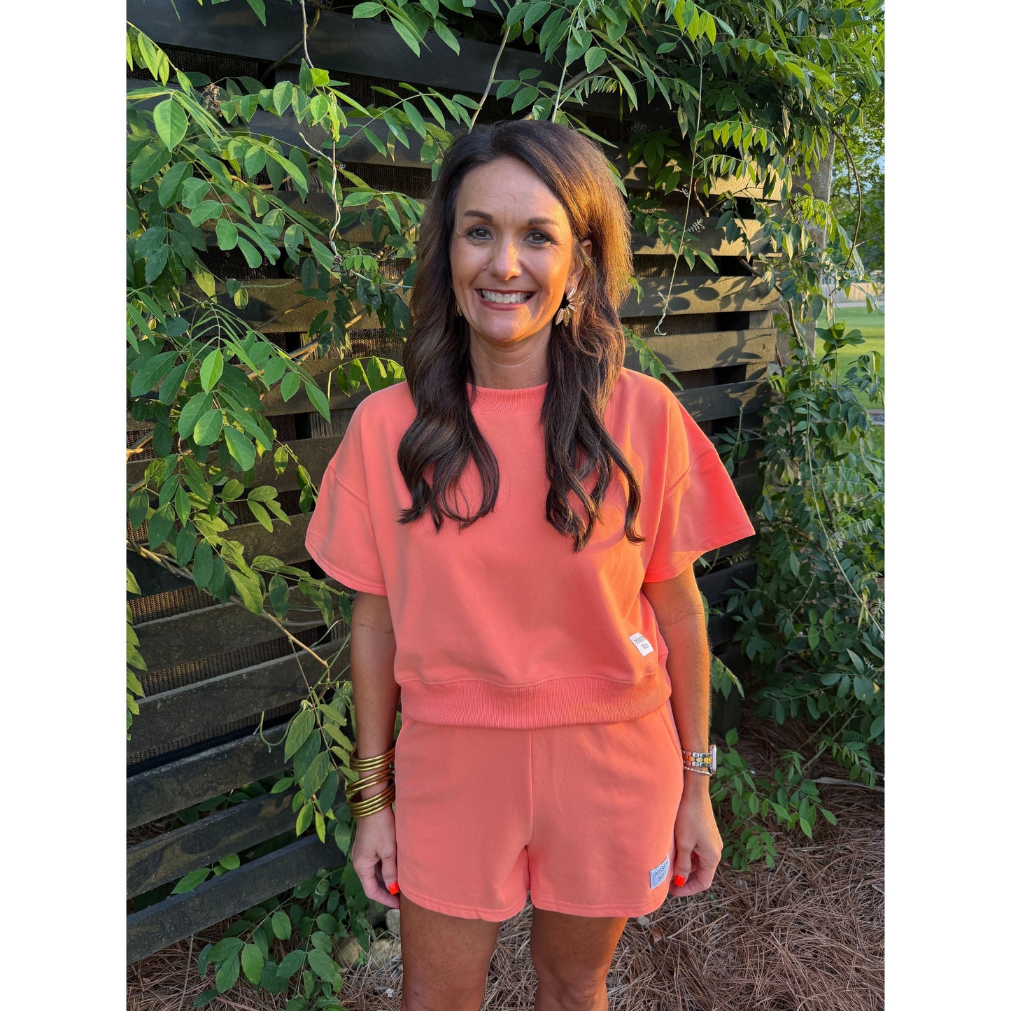 Annie Ks Boutique Watermelon Sugar short set in coral cotton blend worn by a woman outdoors.