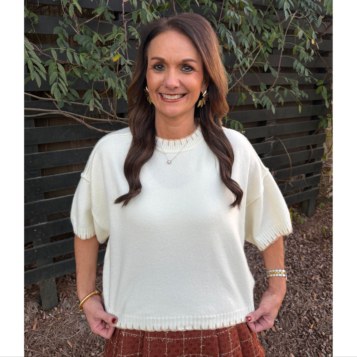 Annie Ks Boutique white mock neck sweater with contrast blanket stitch detail worn by a woman outdoors