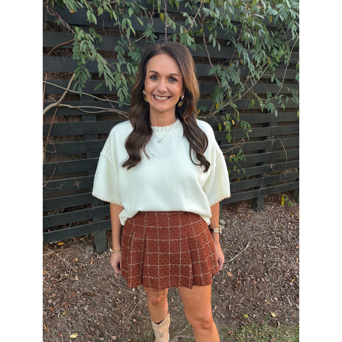 Annie Ks Boutique white mock neck sweater with contrast blanket stitching worn with a brown plaid mini skirt