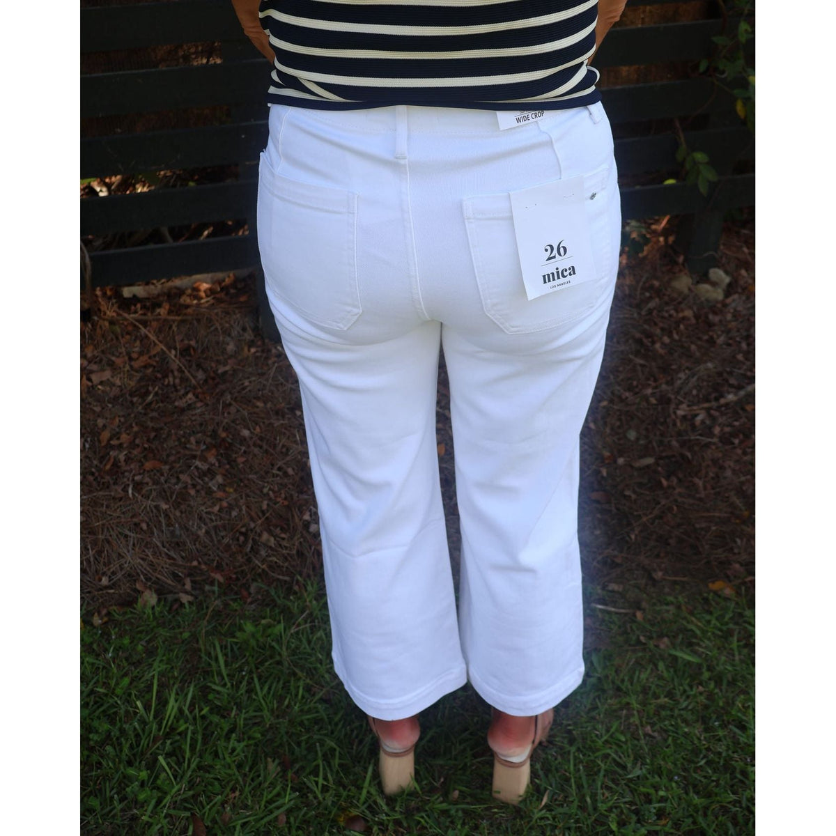 Annie Ks Boutique white wide leg pants with a high-rise fit and back pockets, worn with a striped top