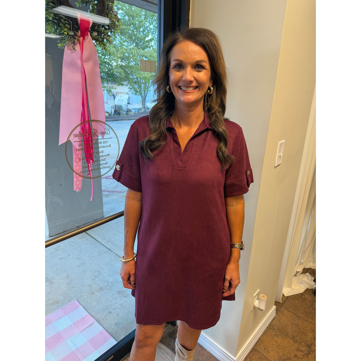 A woman wearing an Annie Ks Boutique wine-coloured faux suede mini dress with a collar and short sleeves.
