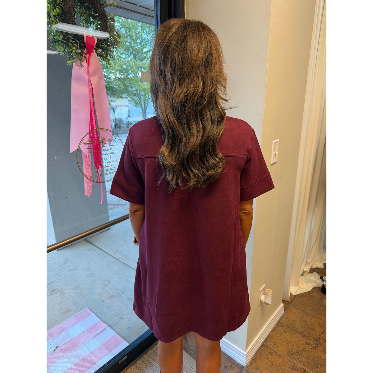 Back view of Annie Ks Boutique wine faux suede mini dress with short sleeves and a collar on a woman