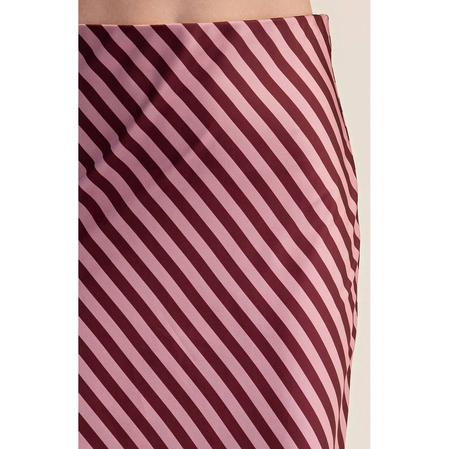 Close-up of a skirt with diagonal stripes in dusty pink and deep burgundy, showing the fabric texture and pattern.