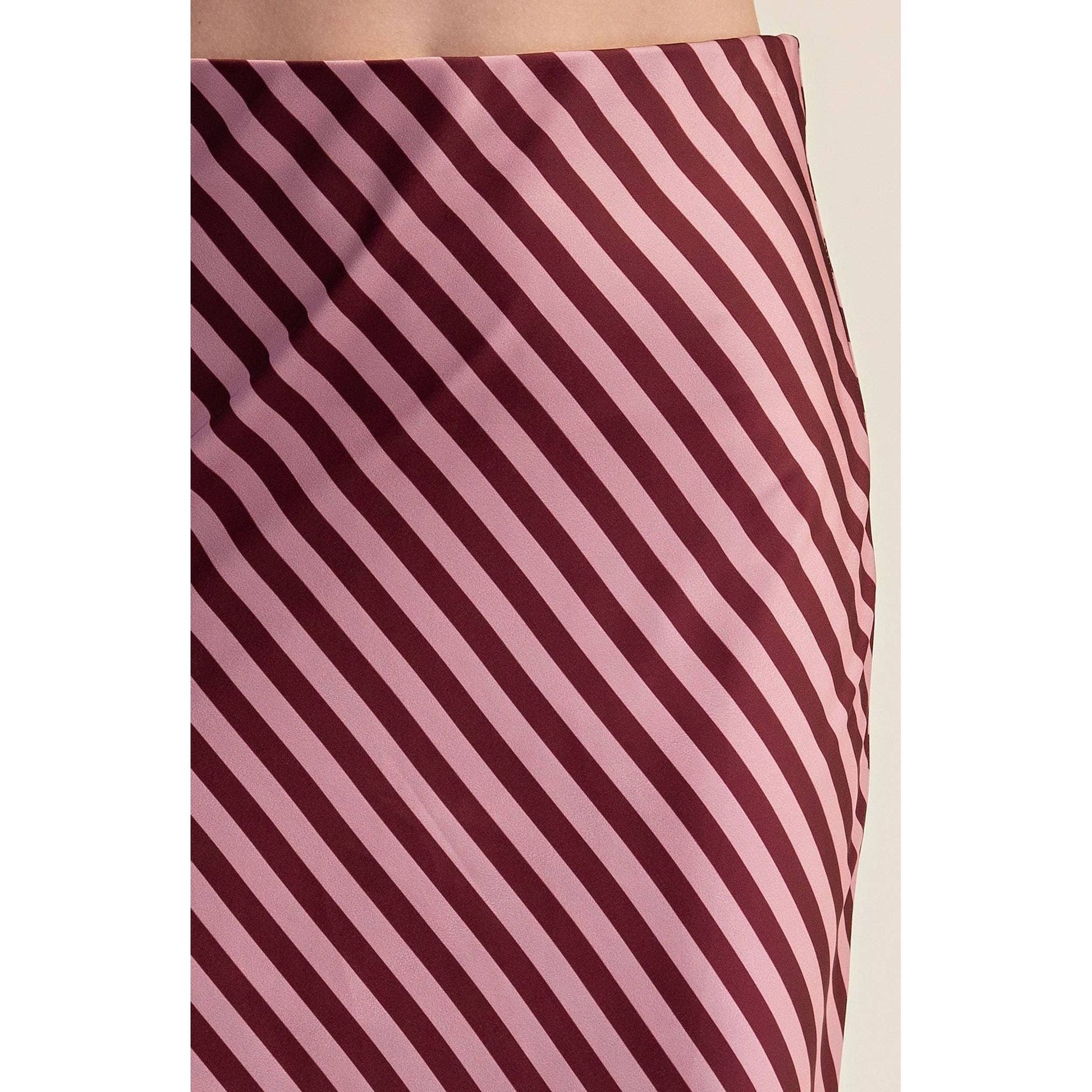 Close-up of a skirt with diagonal stripes in dusty pink and deep burgundy, showing the fabric texture and pattern.