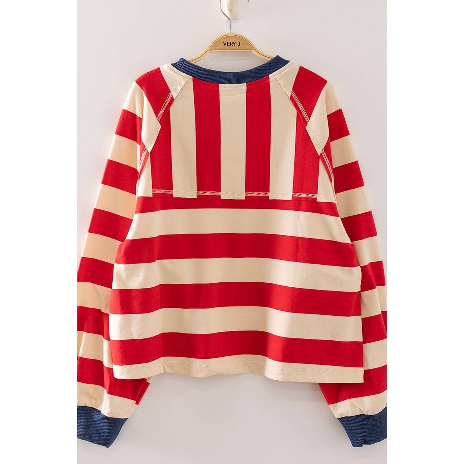 A red and cream striped long-sleeve raglan sweatshirt hanging on a wooden hanger with 'VIEW J' printed on it, set against a plain light background.